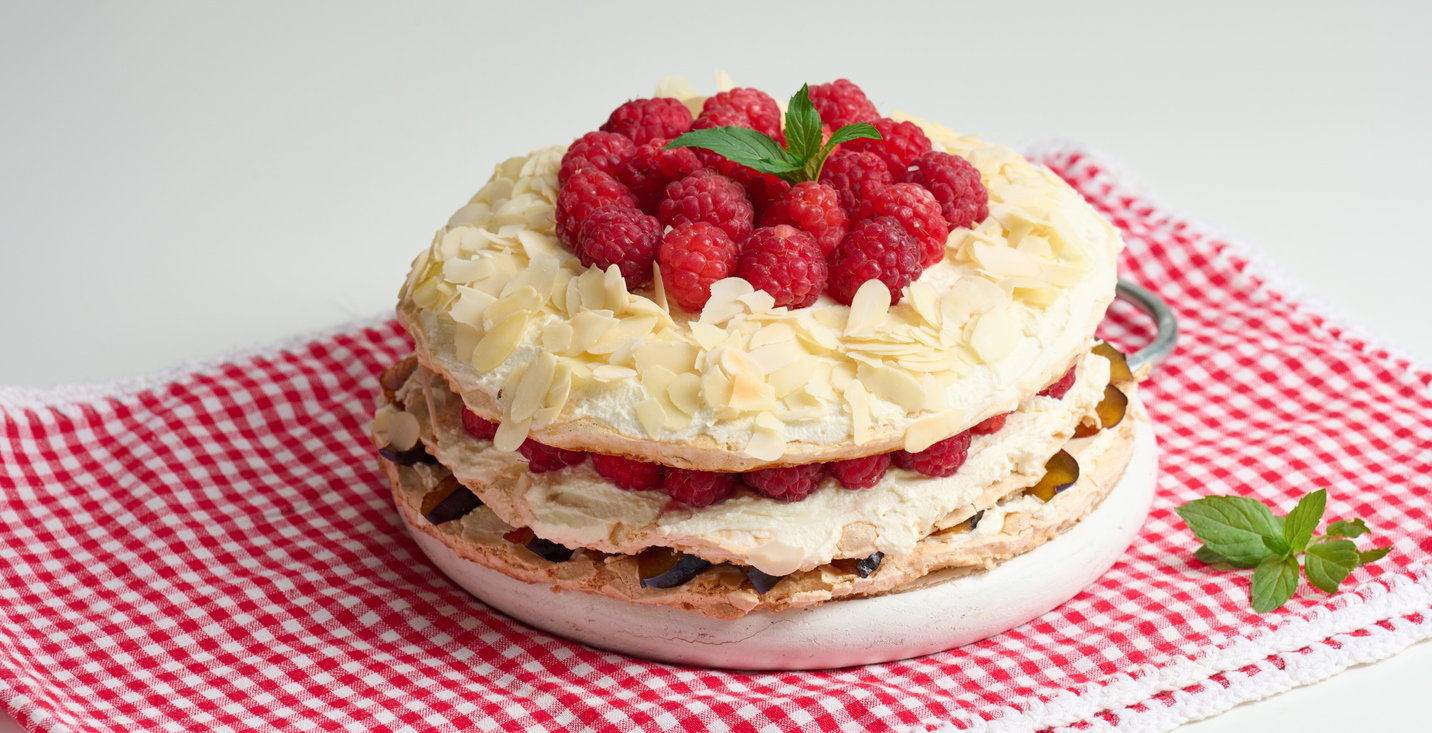 Tort bezowy z bitą śmietaną, serkiem mascarpone i malinami